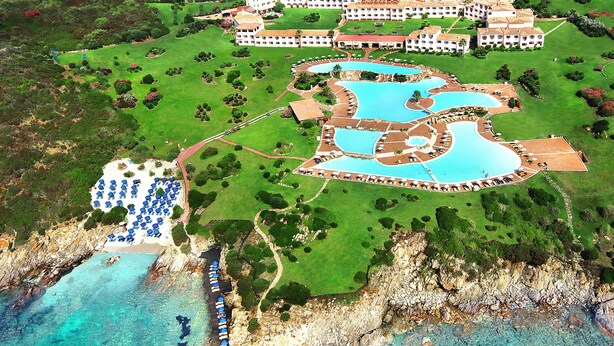 Une vue aérienne d’un complexe hôtelier comprenant plusieurs piscines, une plage et un grand ensemble de bâtiments.