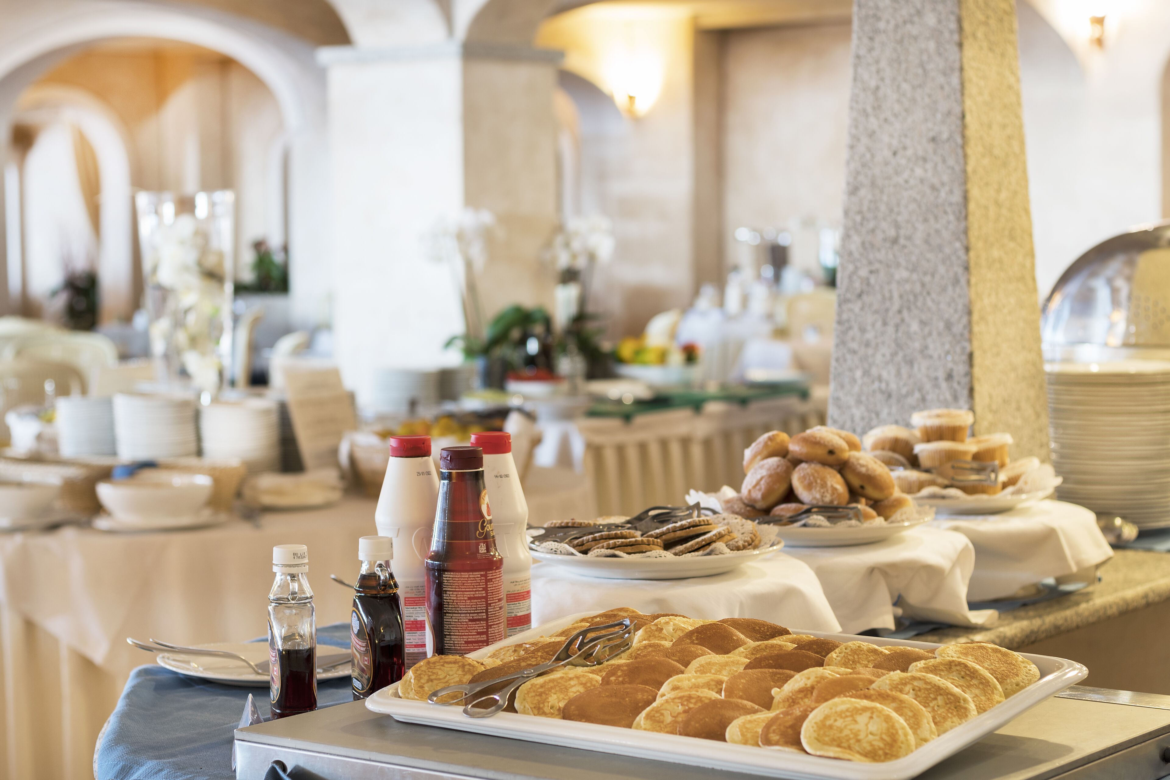 A buffet setup with various food items and condiments.