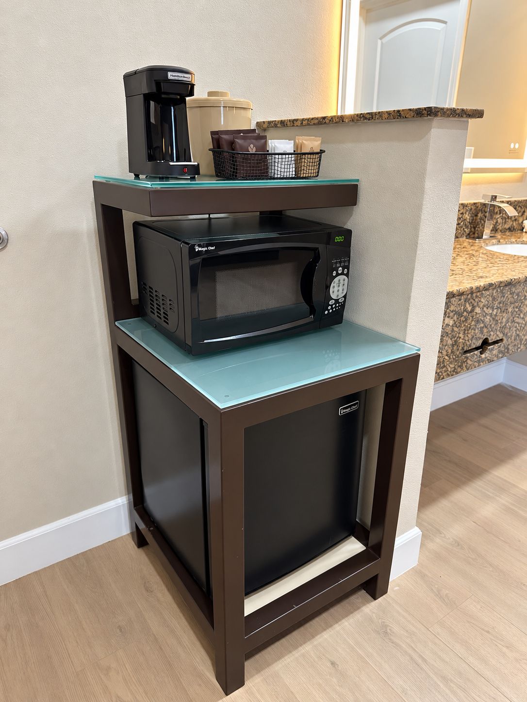 A compact kitchen with a microwave and coffee maker on a small countertop.
