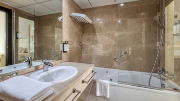 Un baño moderno con dos lavamanos, una bañera y una cabina de ducha de vidrio.