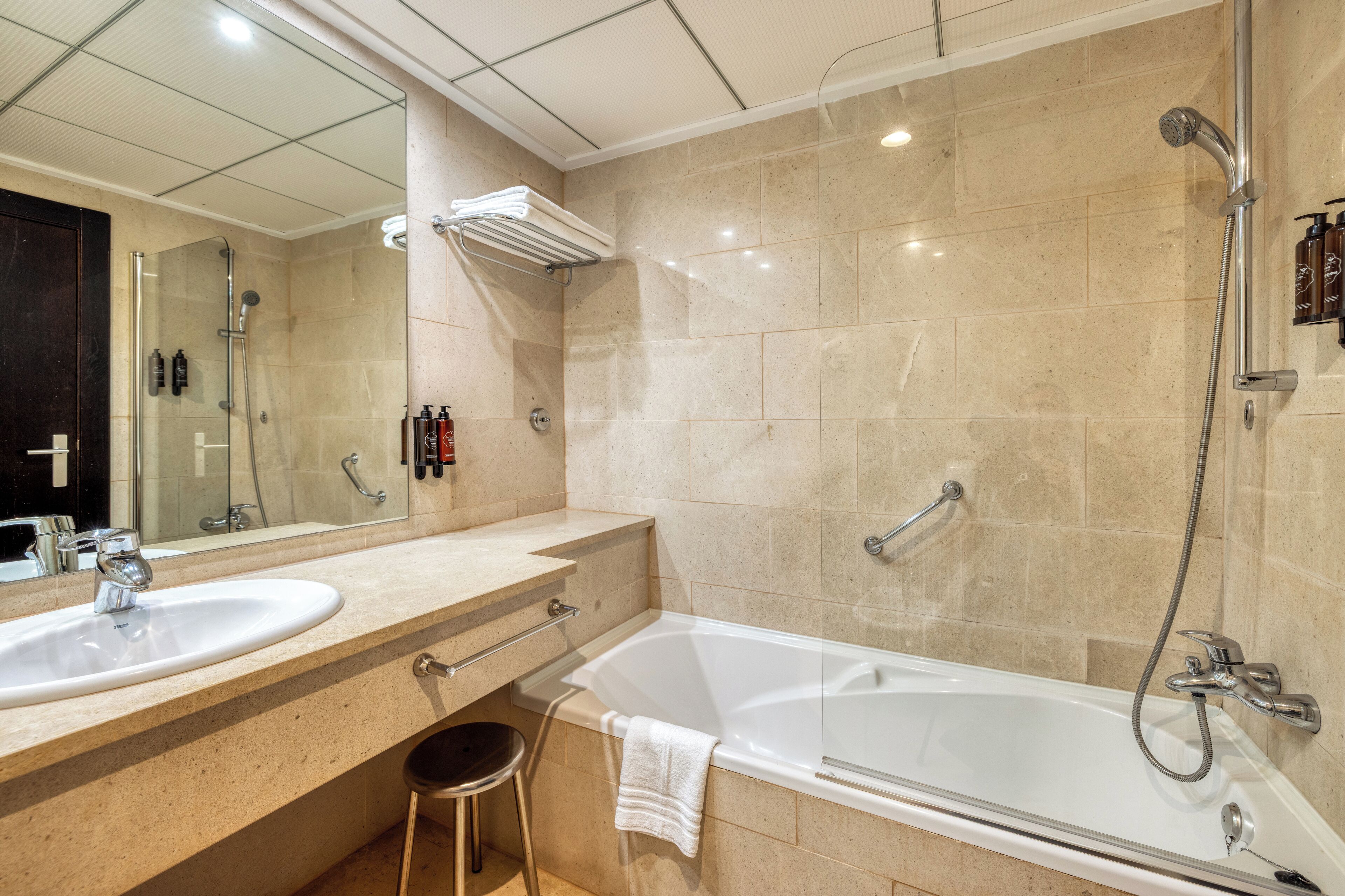 A modern bathroom with two sinks, a bathtub, and a shower.