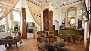 A spacious lobby with wooden flooring, a bar area, and seating arrangements. - Plaza Camelinas Hotel (Querétaro)