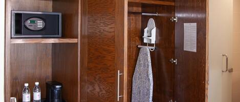 A hotel room with a wooden wardrobe, a microwave, a coffee maker, and a compact dishwasher.