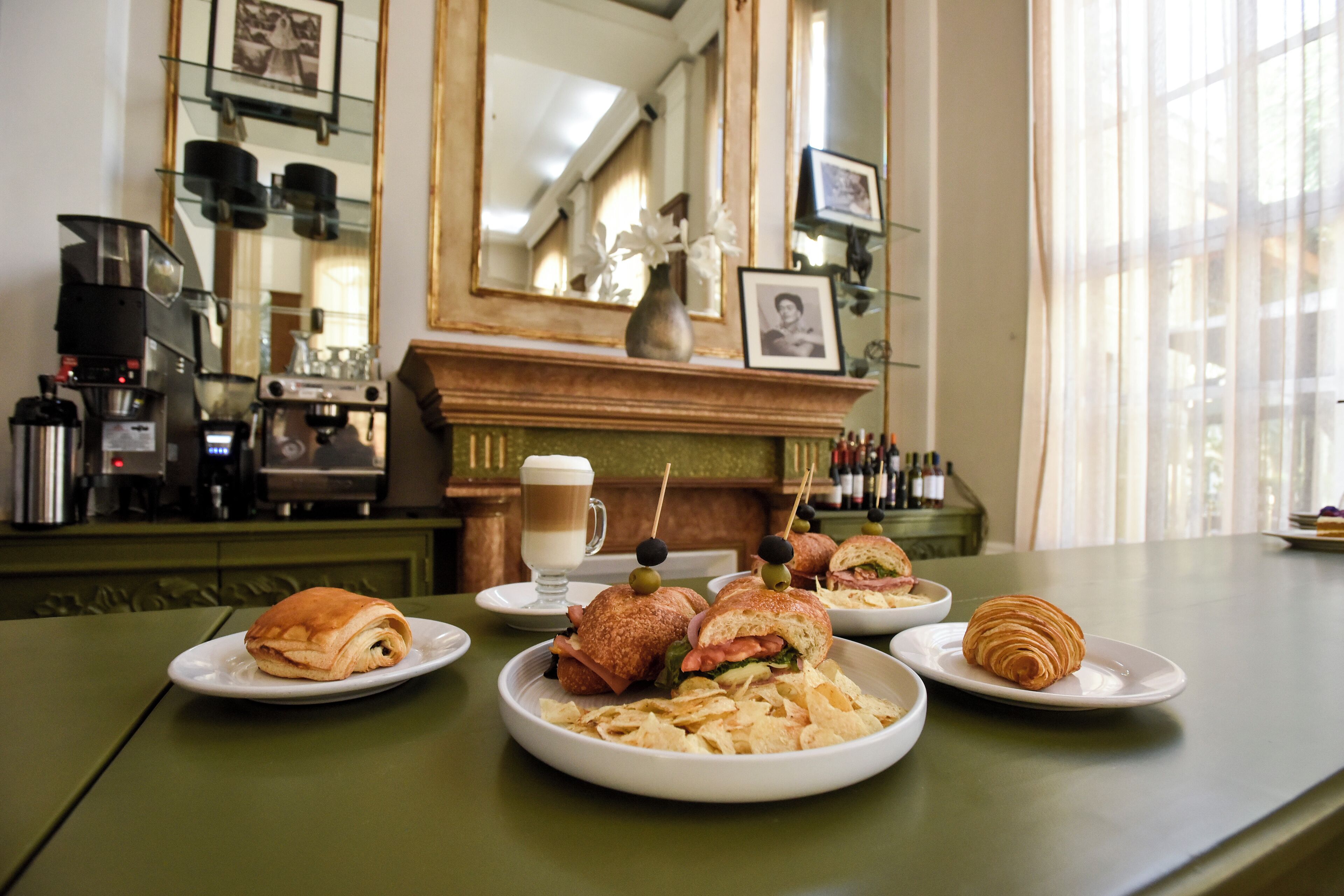 Una mesa con comida, una máquina de café y un espejo en un café.