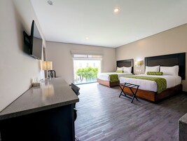 Una habitación de hotel moderna con dos camas, un escritorio y un televisor.