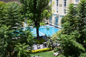 Una piscina rodeada de exuberante vegetación y edificios modernos.