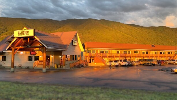 Glacier Basecamp Lodge with a covered entrance, a lobby, and a parking area. - Glacier Basecamp Lodge (Columbia Falls)