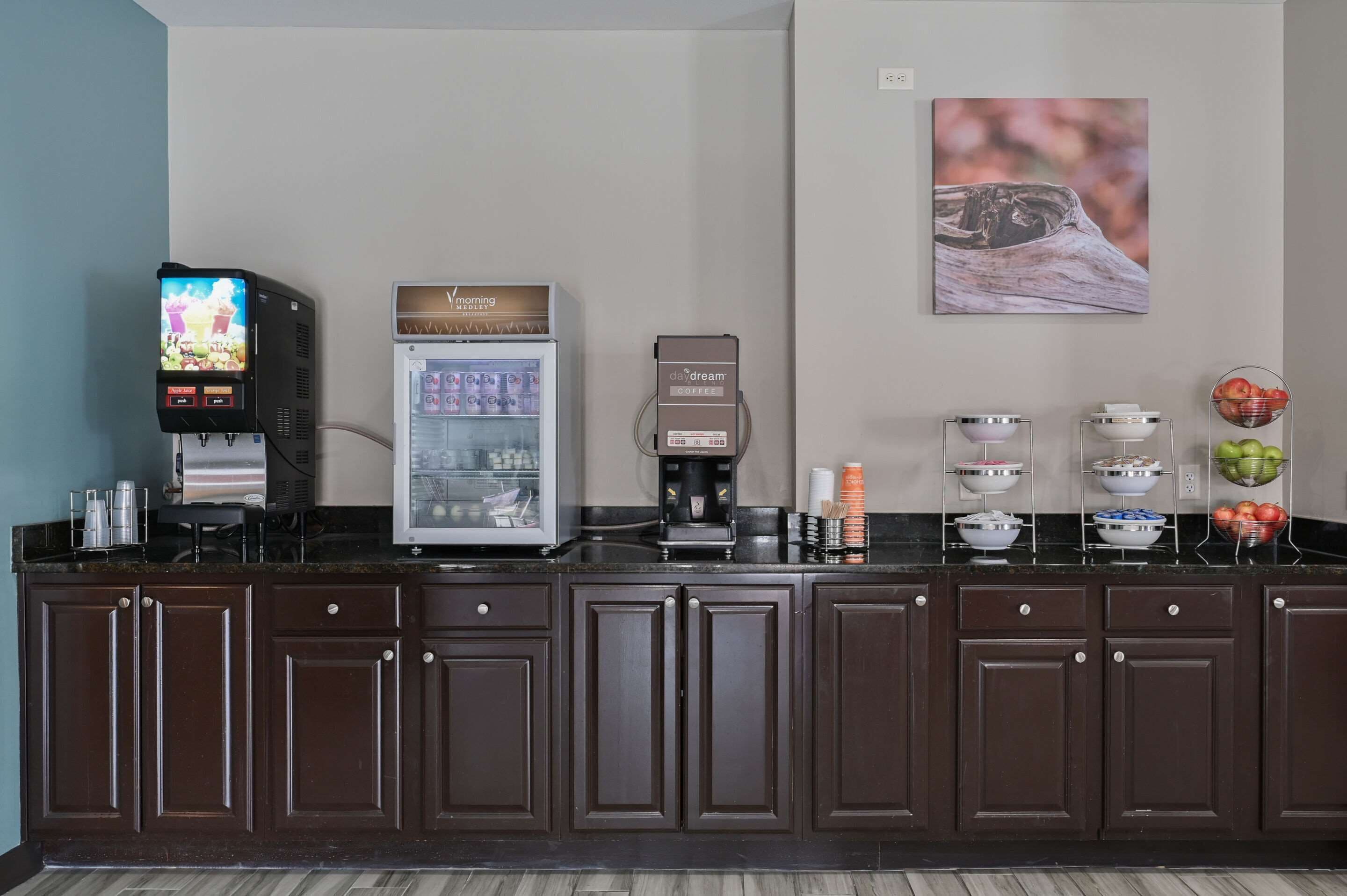 A kitchen area with a coffee machine, a refrigerator, and a television displaying a game.