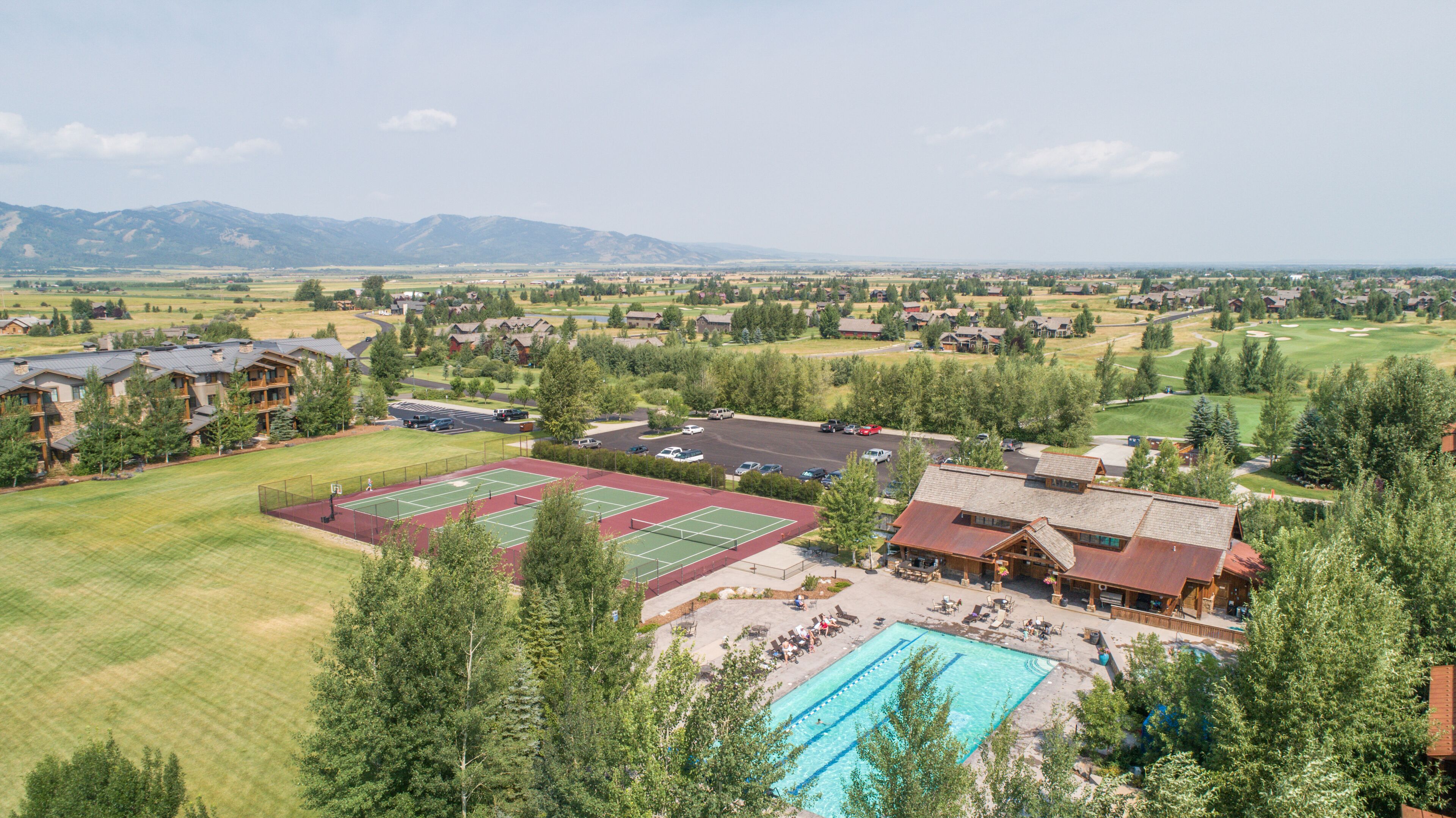 Un complexe hôtelier doté de plusieurs courts de tennis, d’une piscine et, au loin, d’un parcours de golf.