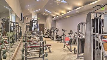 A gym with various exercise equipment, including treadmills, weight machines, and free weights.