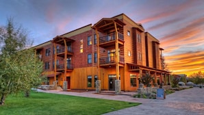 A multi-story building with a wooden facade, balconies, and a stone foundation. - The Lodge at Bronze Buffalo Ranch (Victor)