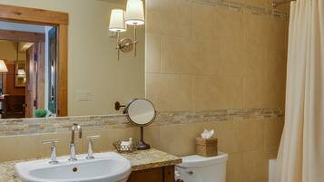 A bathroom with a sink, mirror, and toilet.
