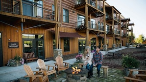 A wooden building with outdoor seating, a fire pit, and a sign reading "SAGE GOURMET". - The Lodge at Bronze Buffalo Ranch (Victor)