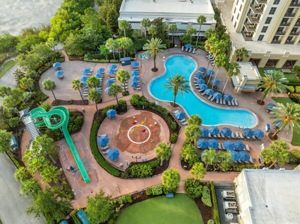 Una piscina al aire libre, sombrillas, sillones reclinables de piscina