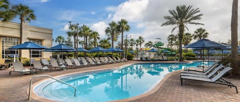 Alberca al aire libre, sombrillas en la alberca y camastros