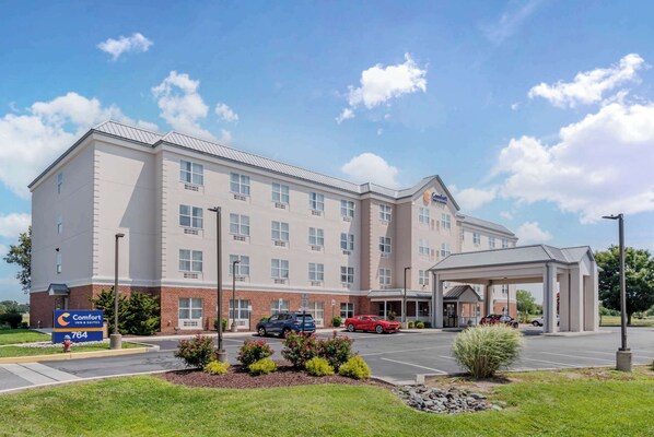 A Comfort Inn & Suites hotel with a covered parking area and a landscaped entrance.