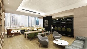 Un'area lounge moderna con vista sulla città, un cartello che indica la colazione e un bar con scaffali pieni di bottiglie.