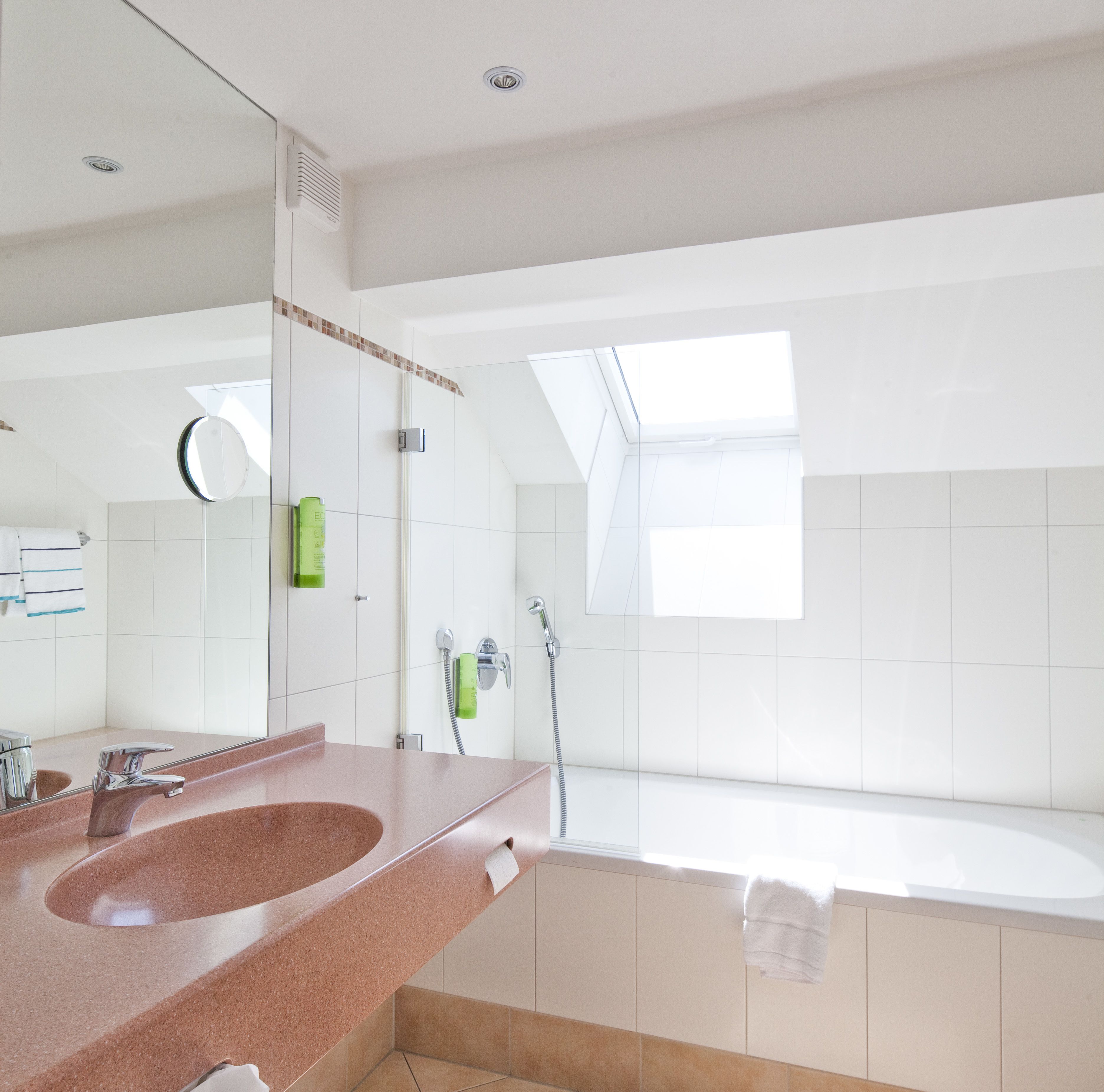 Un baño moderno con un lavamanos grande, un espejo, una ducha y una bañera.