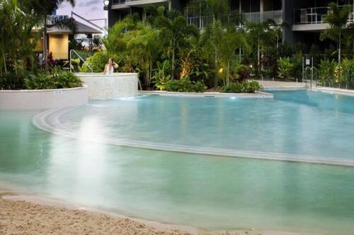 Una piscina al aire libre, sombrillas, tumbonas