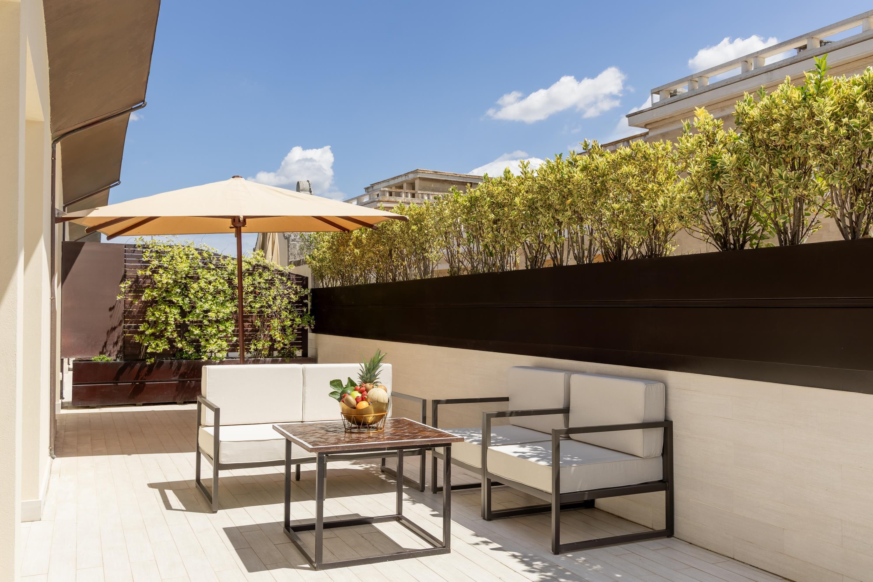 An outdoor patio with a table, chairs, and a large umbrella.