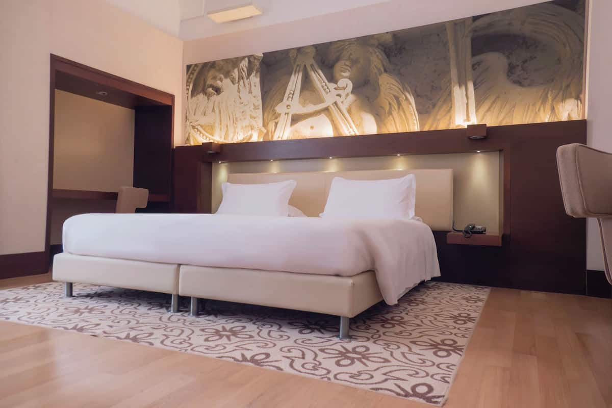 Junior Suite Deluxe | Ylelliset vuodevaatteet, minibaari, tallelokero huoneessa, työpöytä