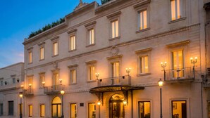 Un hotel de varios pisos con fachada clásica, ventanas grandes y una entrada central con dosel.