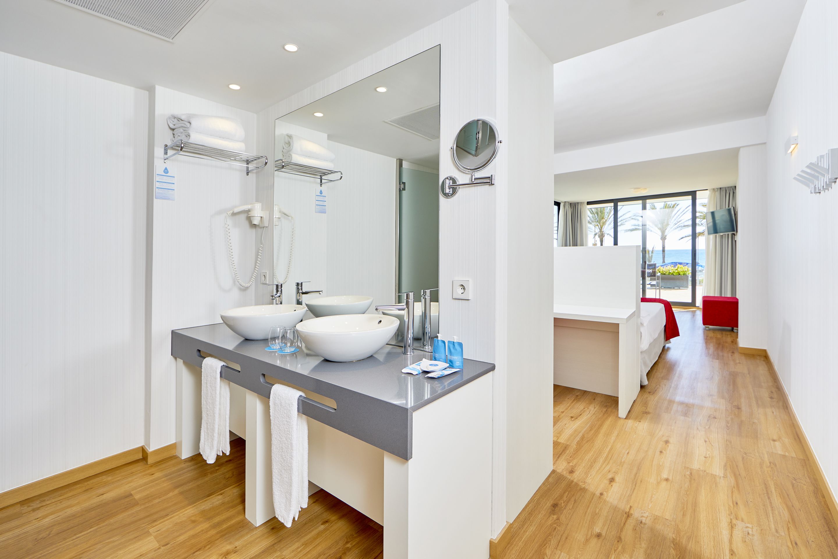A modern bathroom with two sinks, a mirror, and a shower.
