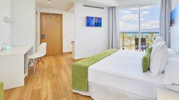 Una habitación de hotel con cama, escritorio, silla y televisión.