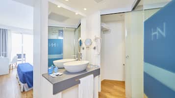 A modern bathroom with two sinks, a large mirror, and a glass shower enclosure.