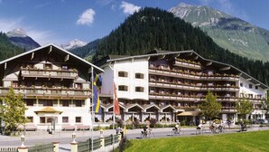 A hotel with multiple balconies and a mountain backdrop. - Alpenrose - Wellnessresort (Elbigenalp)