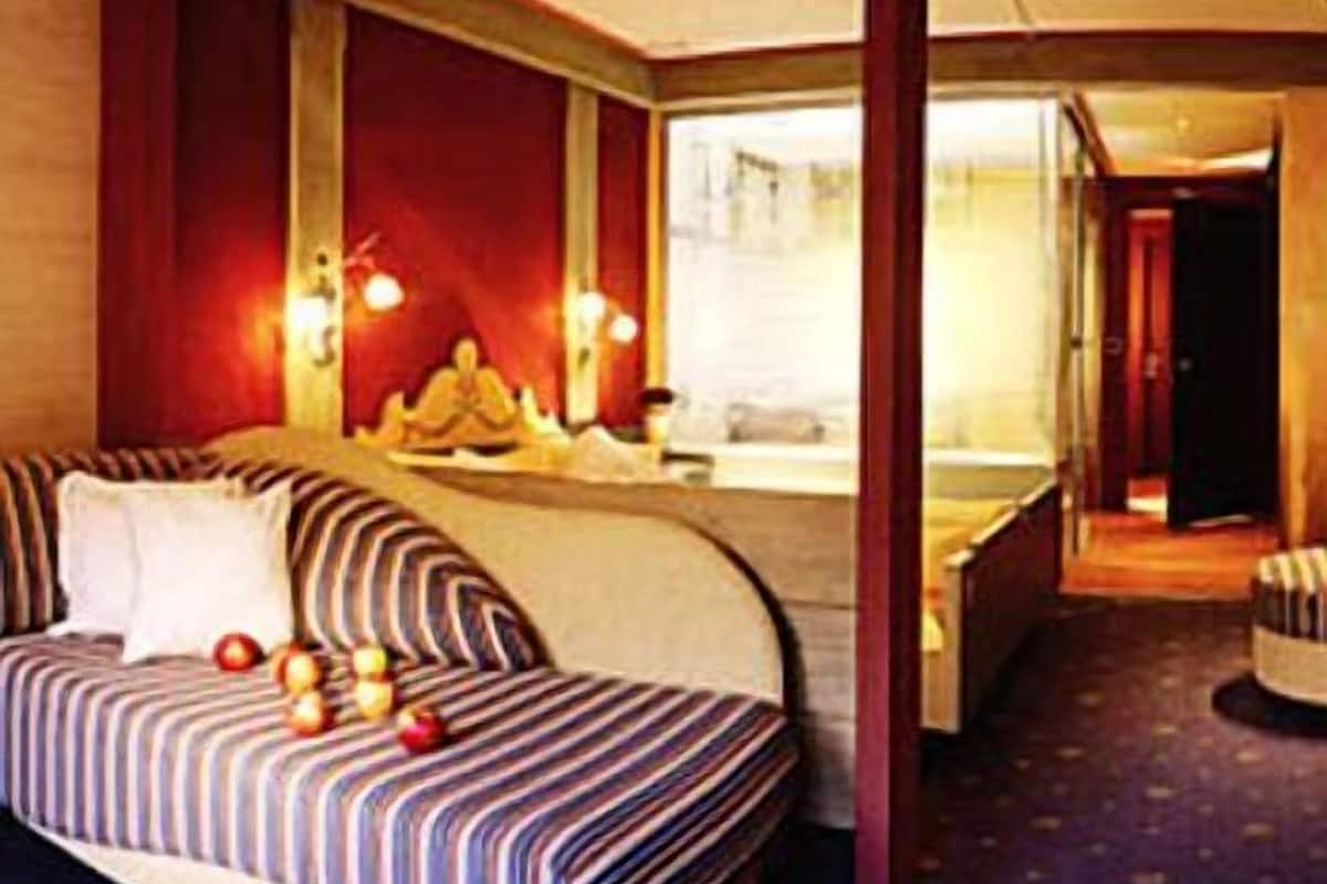 Une chambre d’hôtel avec un lit, une coiffeuse avec un miroir et une vue sur la rue.