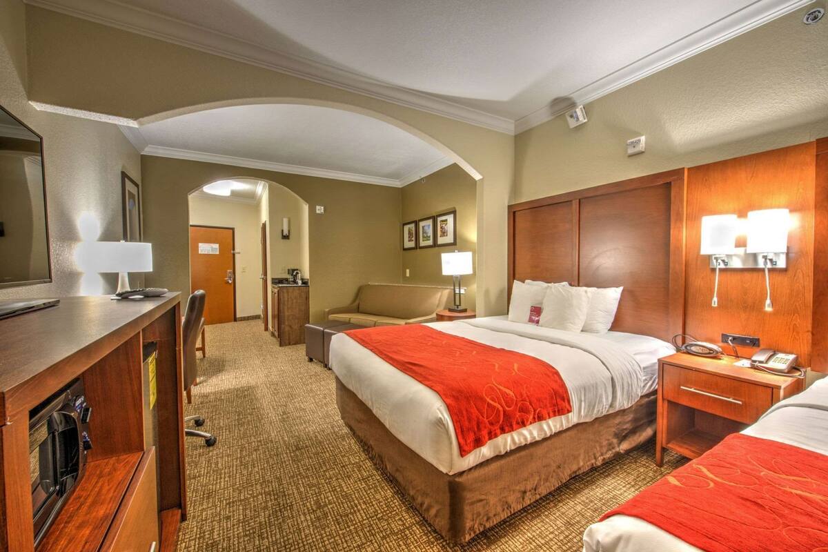 Une chambre d’hôtel équipée d’un lit, d’un bureau, d’une chaise, d’une table de chevet et d’un téléviseur.