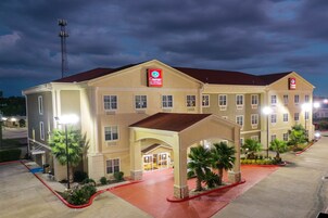 Un hotel Comfort Suites con entrada central, varias ventanas y aparcamiento.
