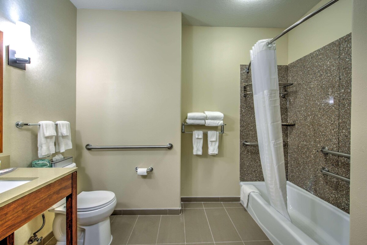 A bathroom with a toilet, sink, and shower area.