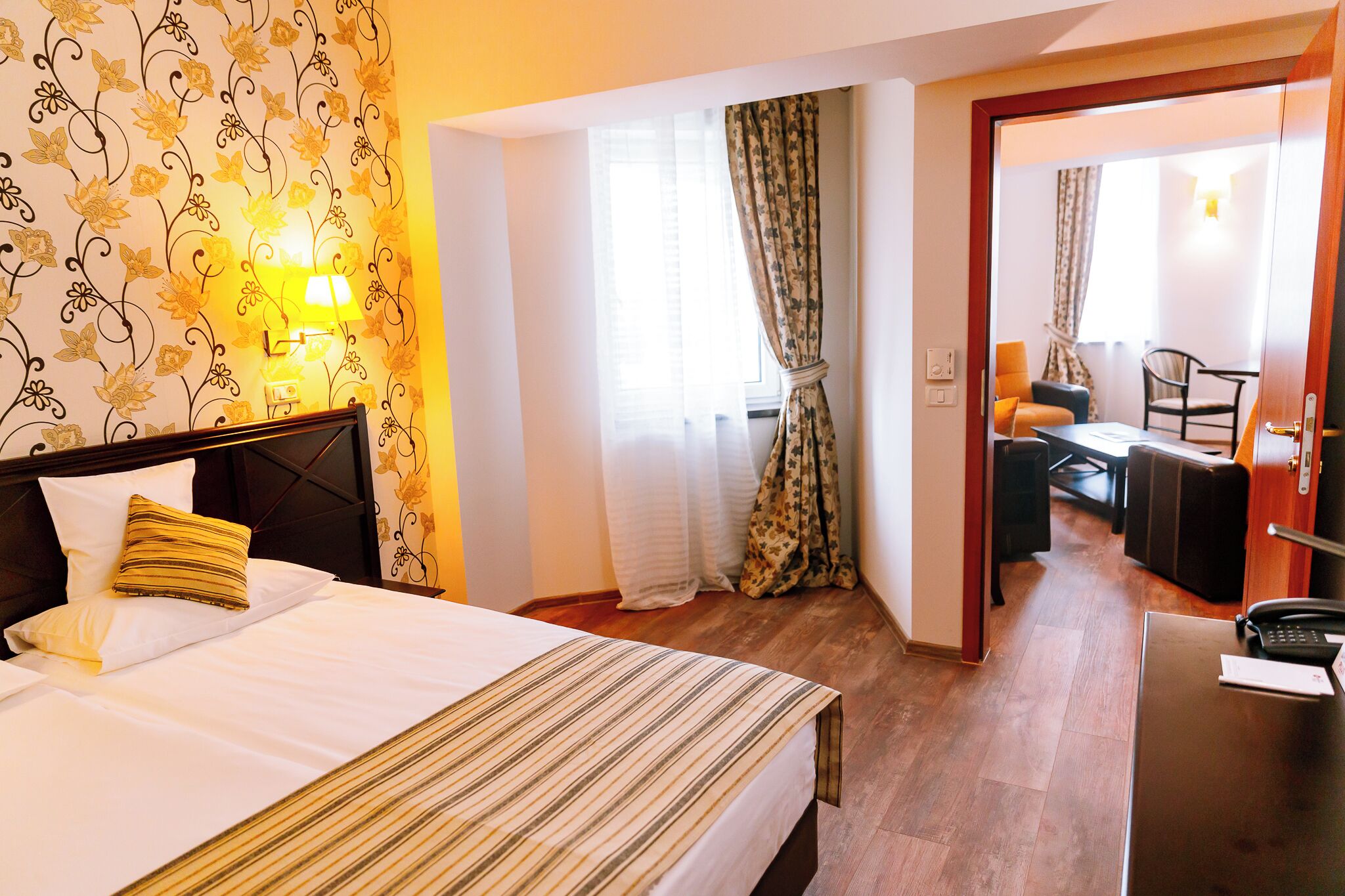 Una habitación de hotel con cama, escritorio, silla y lámpara.