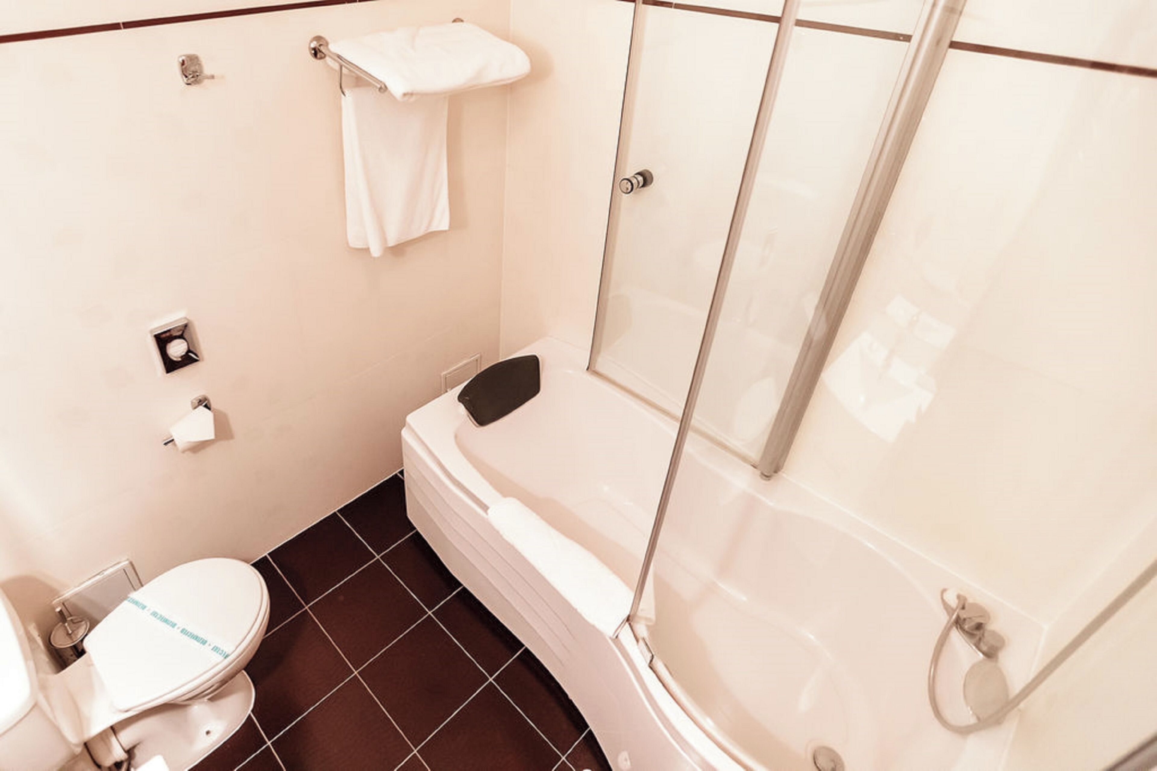 Un baño con inodoro, bañera y cabina de ducha.
