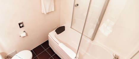 Un baño con inodoro, bañera y cabina de ducha.