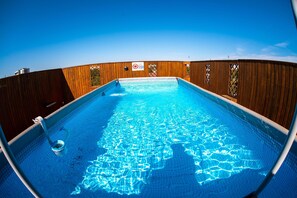 Een buitenzwembad en ligstoelen