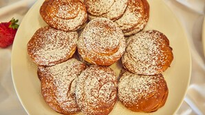 Une assiette de viennoiseries fra îchement sorties du four, saupoudrées de sucre glace.