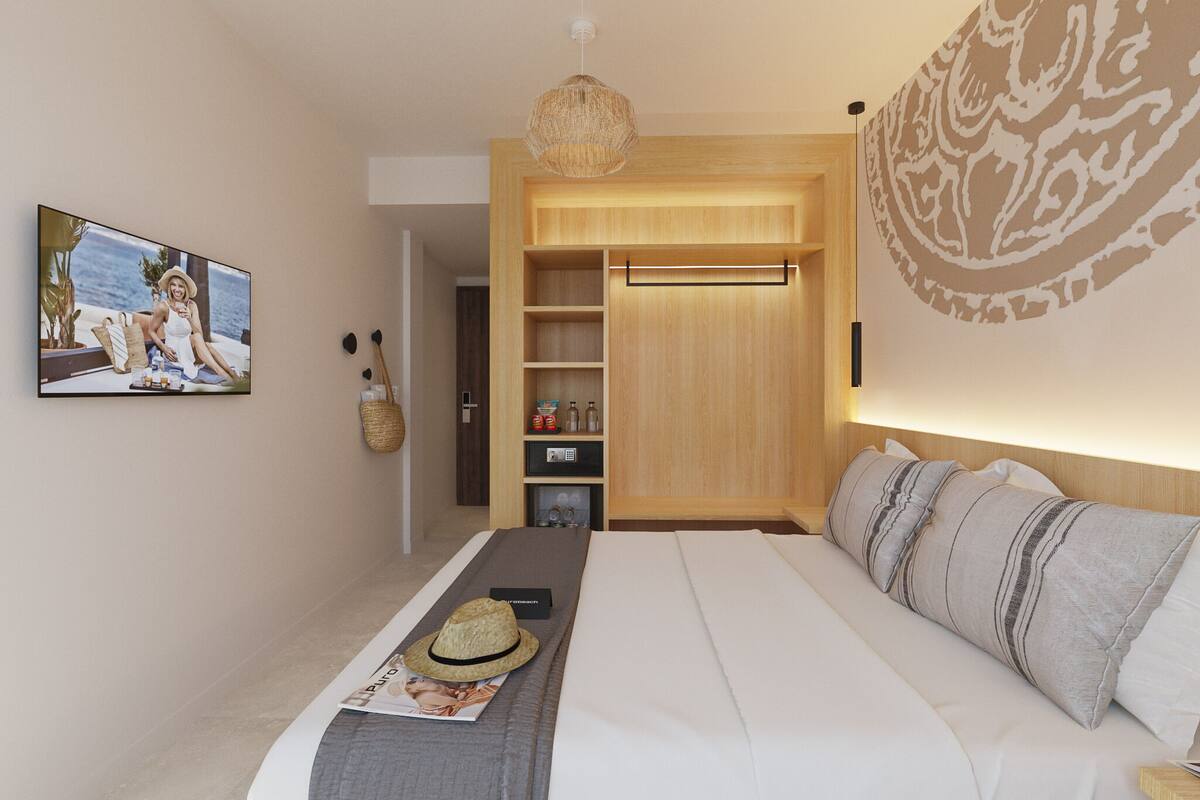 Ein modernes Schlafzimmer mit einem großen Bett, einem Holzschrank, einer hängenden Körbotm und einem an der Wand montierten Fernseher.