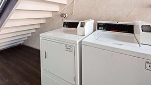 A laundry area with two front-loading washing machines and a dryer. - Downtown Phoenix Hotel (Phoenix)