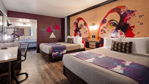 A hotel room with two beds, a desk, and a bathroom visible in the background. - Downtown Phoenix Hotel (Phoenix)