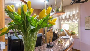 A reception desk with a vase of yellow tulips, a telephone, and a map on the wall. - Roy Hotel (Silea)