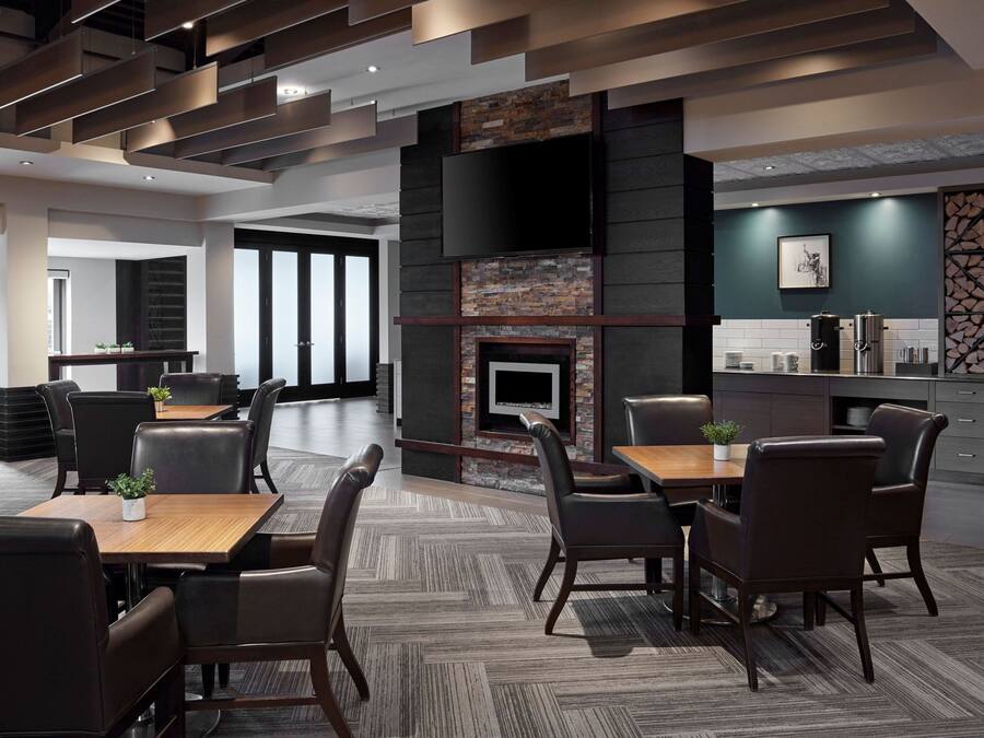 Un restaurante moderno con chimenea, mesas y sillas para comer.