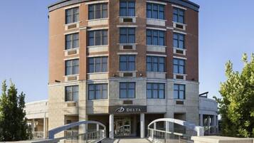 A Delta hotel with a curved facade, multiple floors, and a central entrance with a glass canopy.