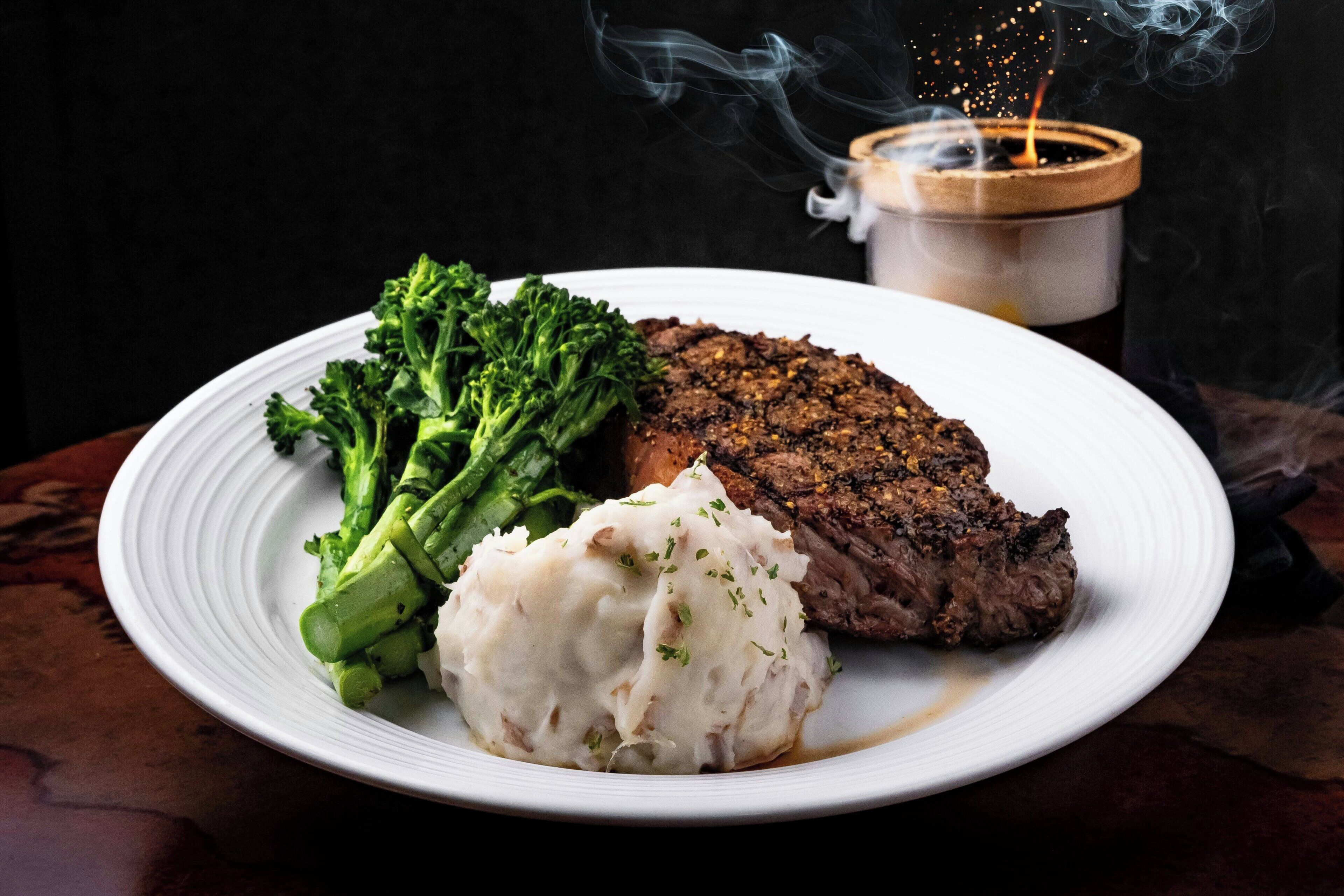 A plate with a steak, broccoli, and mashed potatoes.