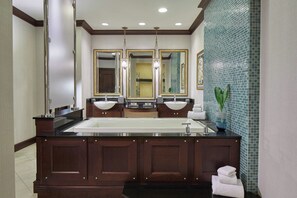 A modern bathroom with a large freestanding sink, double vanity mirrors, and a decorative tile backsplash. - Renaissance Montgomery Hotel & Spa at the Convention Center (Montgomery)