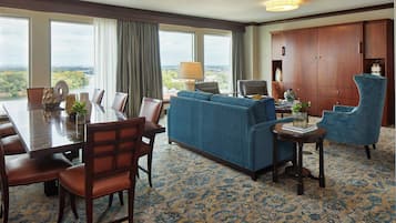 Une chambre d’hôtel avec une table à manger, un canapé bleu et une grande armoire.