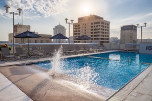 A rooftop pool with a water feature, umbrellas, and lounge chairs. - Renaissance Montgomery Hotel & Spa at the Convention Center (Montgomery)