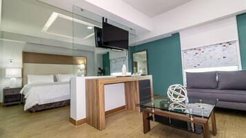 Una habitación de hotel moderna con cama, escritorio, sofá y televisión.